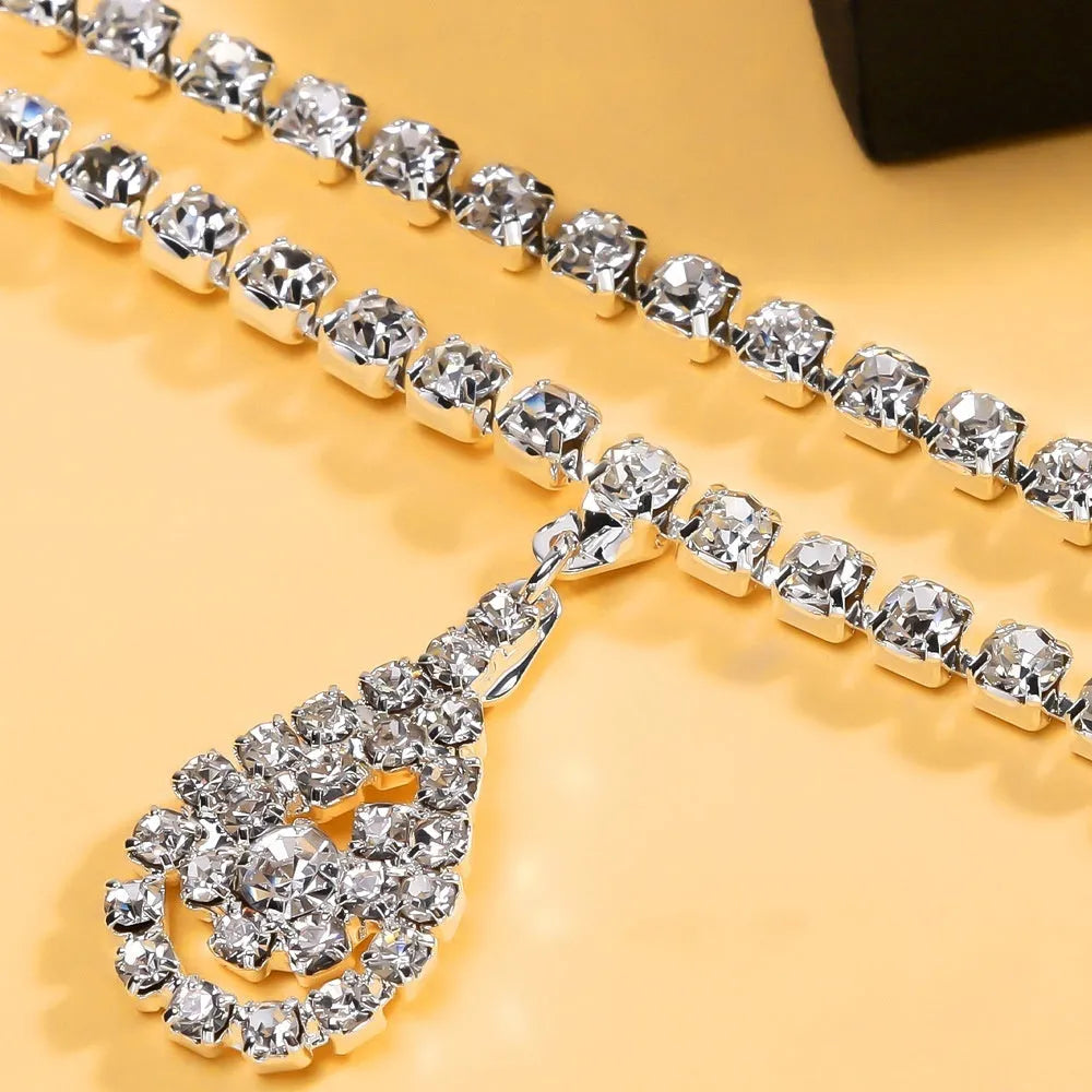 Gold or silver waist chain with a water drop rhinestone pendant and lobster buckle.