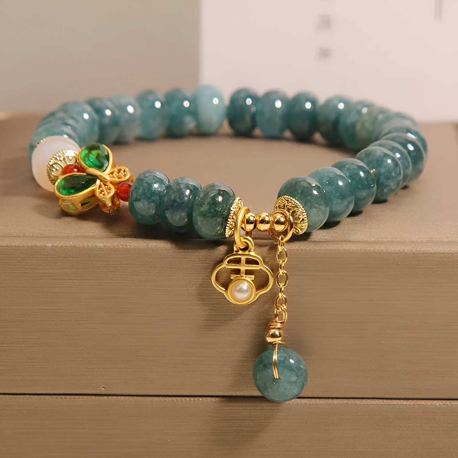 Blue water jade bracelet with white agate abacus beads and butterfly charm
