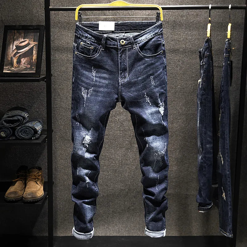 Men's slim-fit skinny jeans in dark blue denim laid flat, showing front design and button fly.