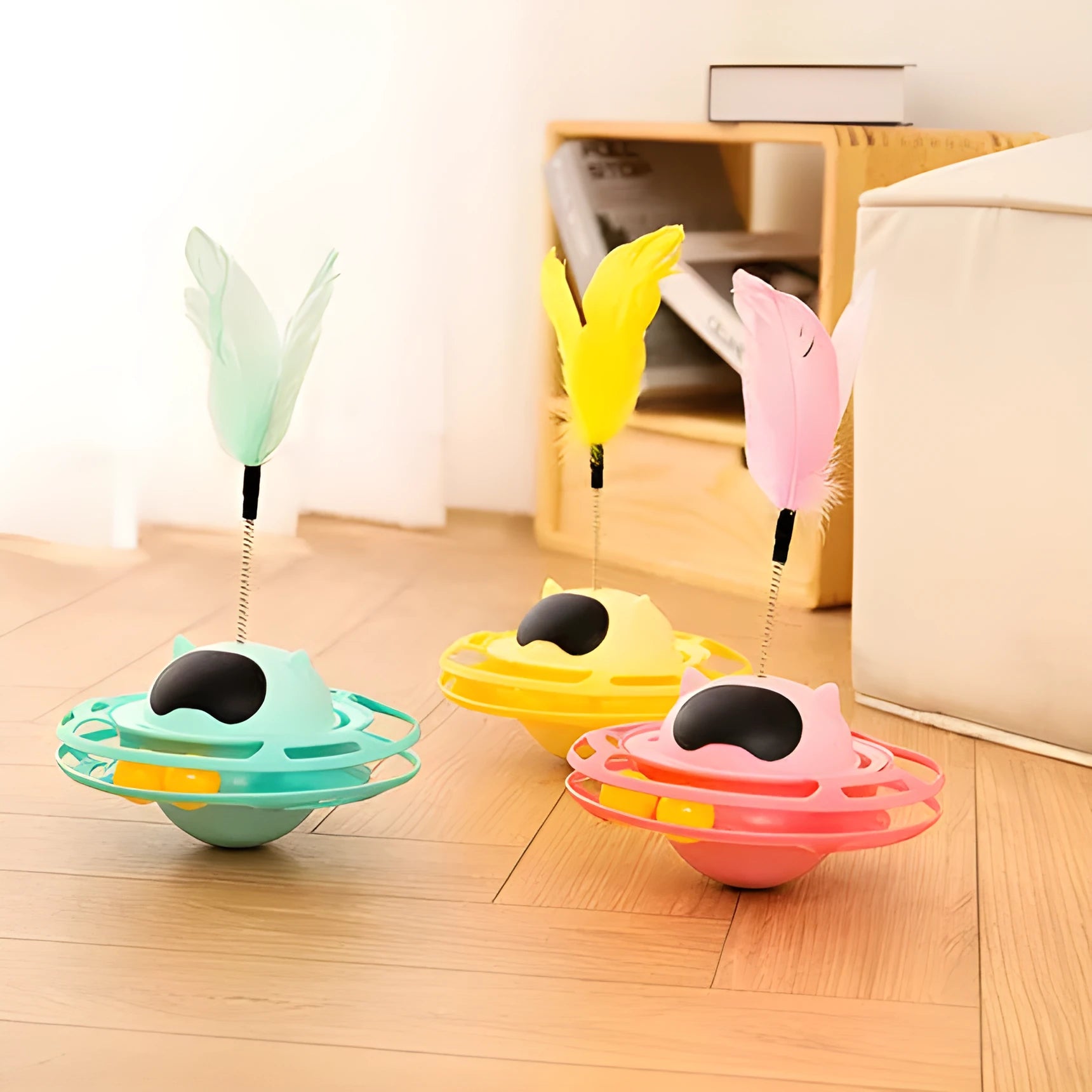 Pink plastic cat tumbler turntable stick toy with feather attachments on a white background.