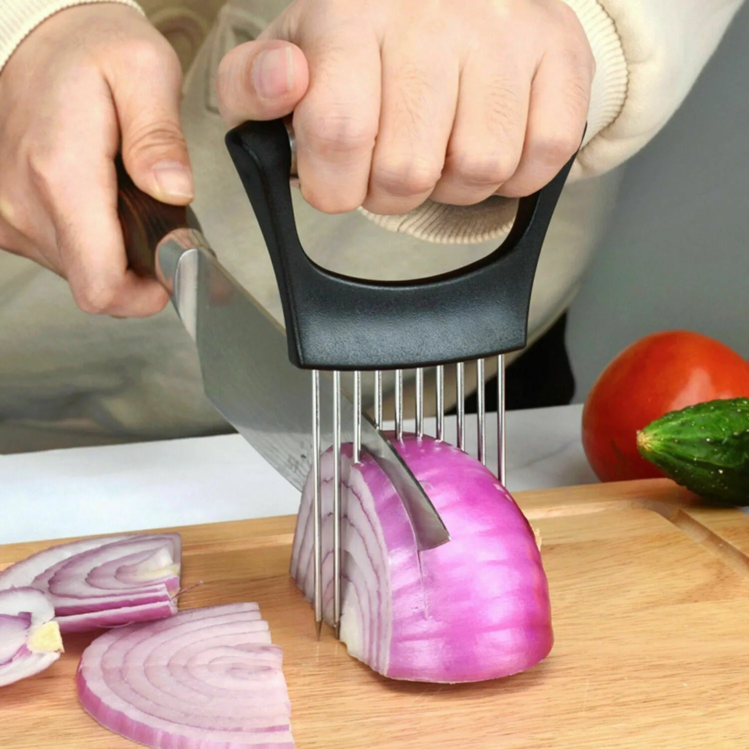 Stainless steel and ABS food slice assistant for onions and tomatoes on a kitchen worktop.