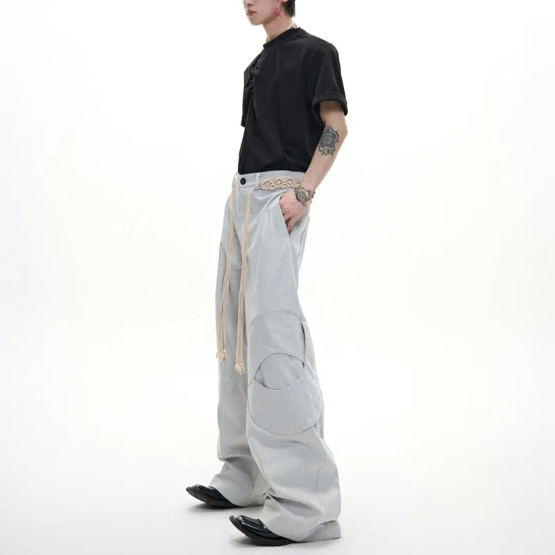 Men's dark blue straight-leg trousers with 3D cutting, zipper decorations, and a tassel pocket detail on a micro-elastic cotton fabric.