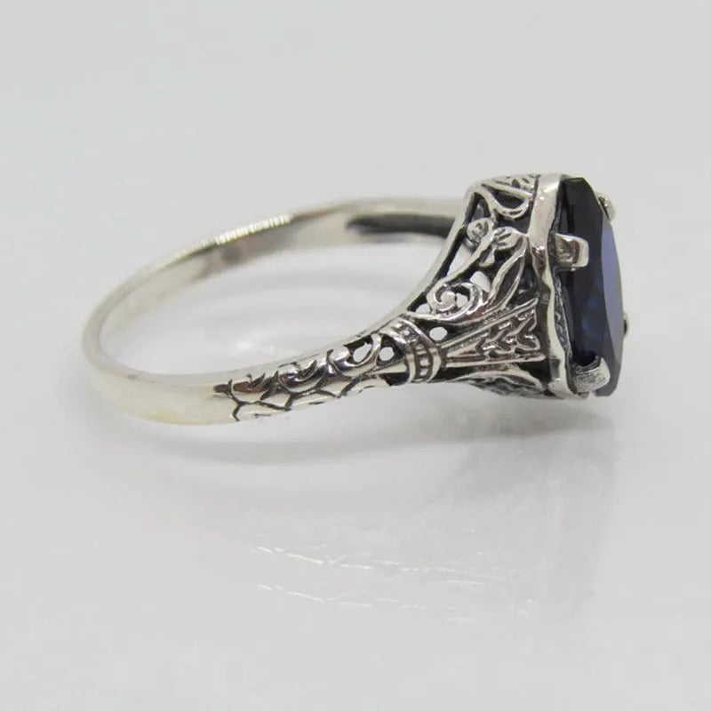 Silver geometric hollow women's ring on grey background showing detailed pattern