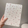 Transparent floral patterned tri-fold protective case for Apple iPad in stand position.