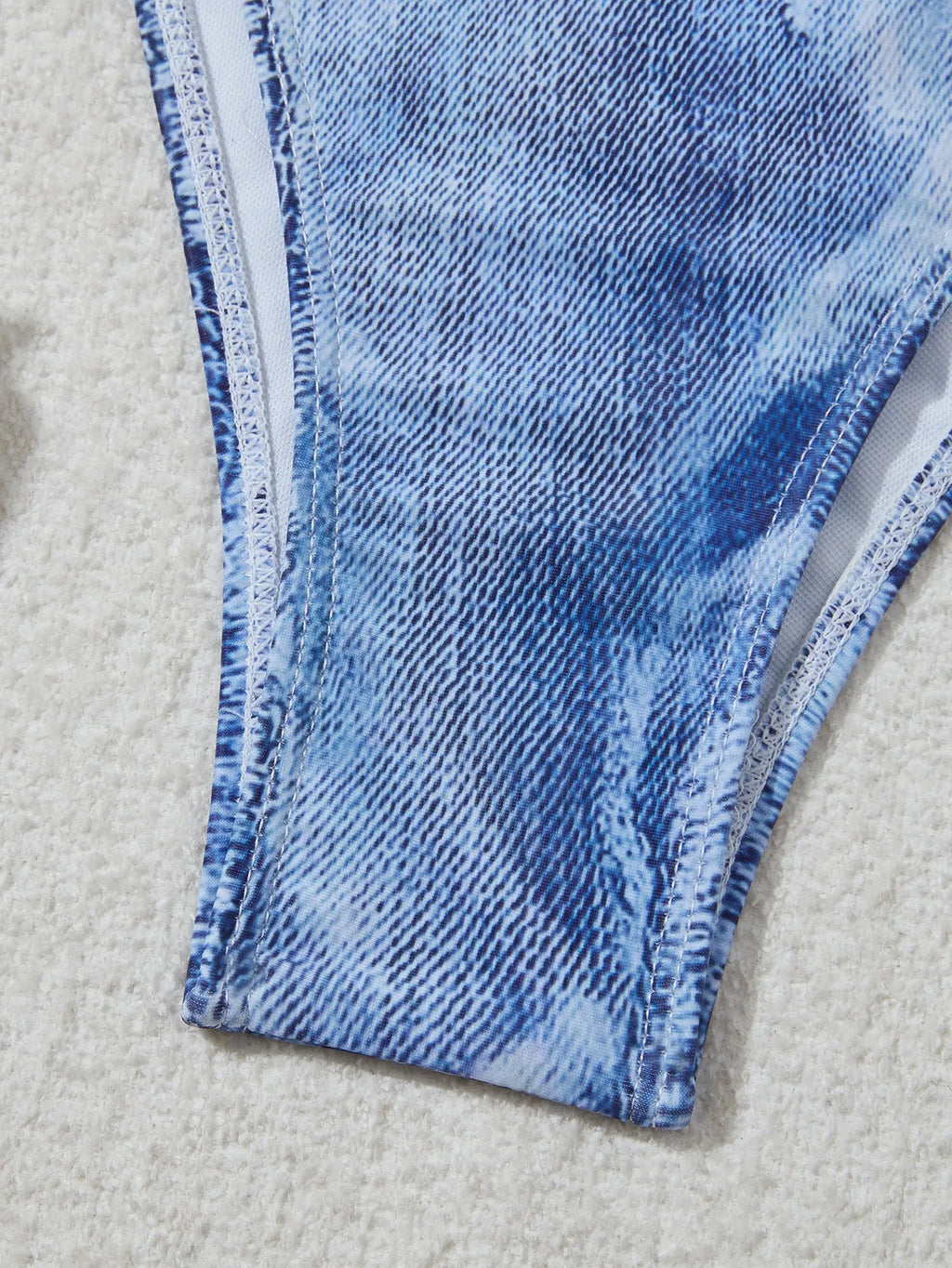 Women's denim blue printed bikini set with halterneck top and side-tie bottoms on a mannequin.