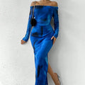 A woman wearing a long green mesh fishtail dress with pleats, a square collar, and a gradient colour print.