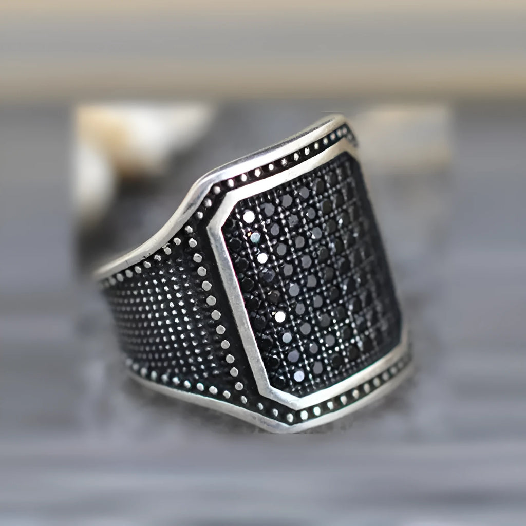 Black alloy ring with copper inlaid zircon detailing showing front view on neutral background