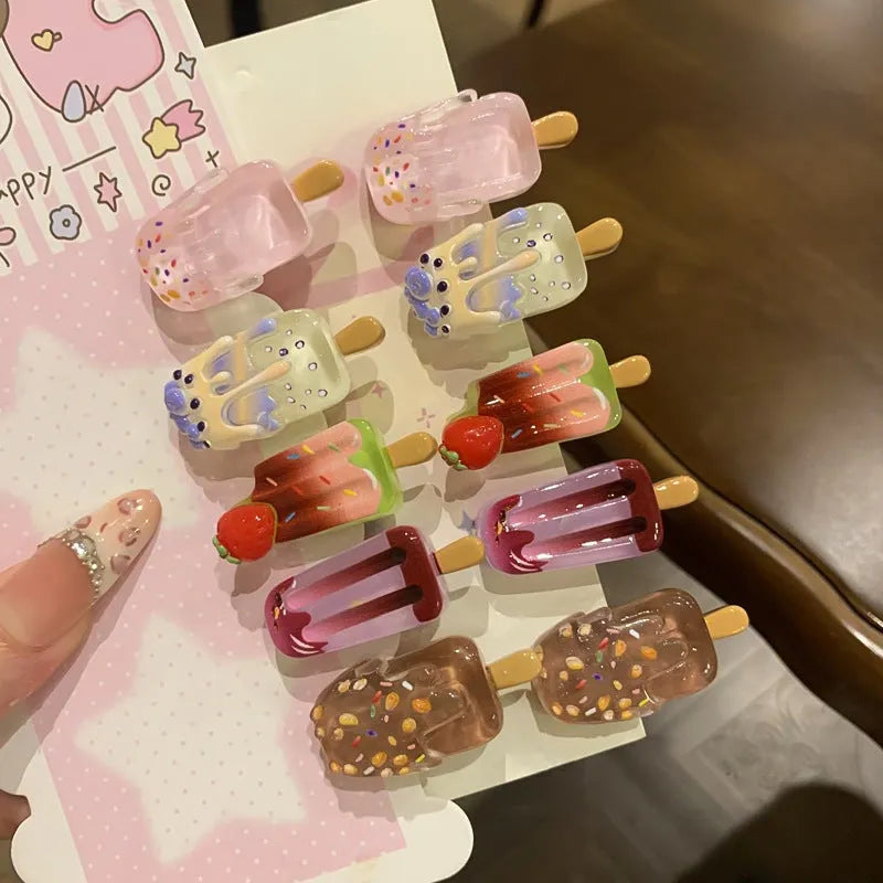 Close-up of a resin hair clip with a colourful cartoon ice cream design, shown in beige.
