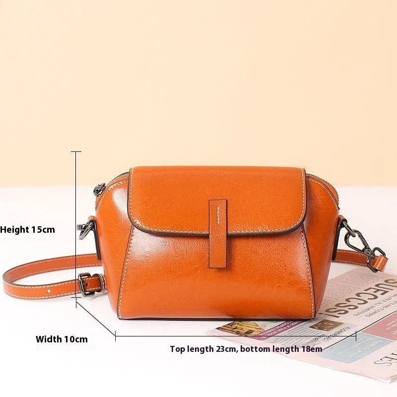 Brown women's crossbody messenger bag in soft oil wax leather with shell shape and visible sewing detailing