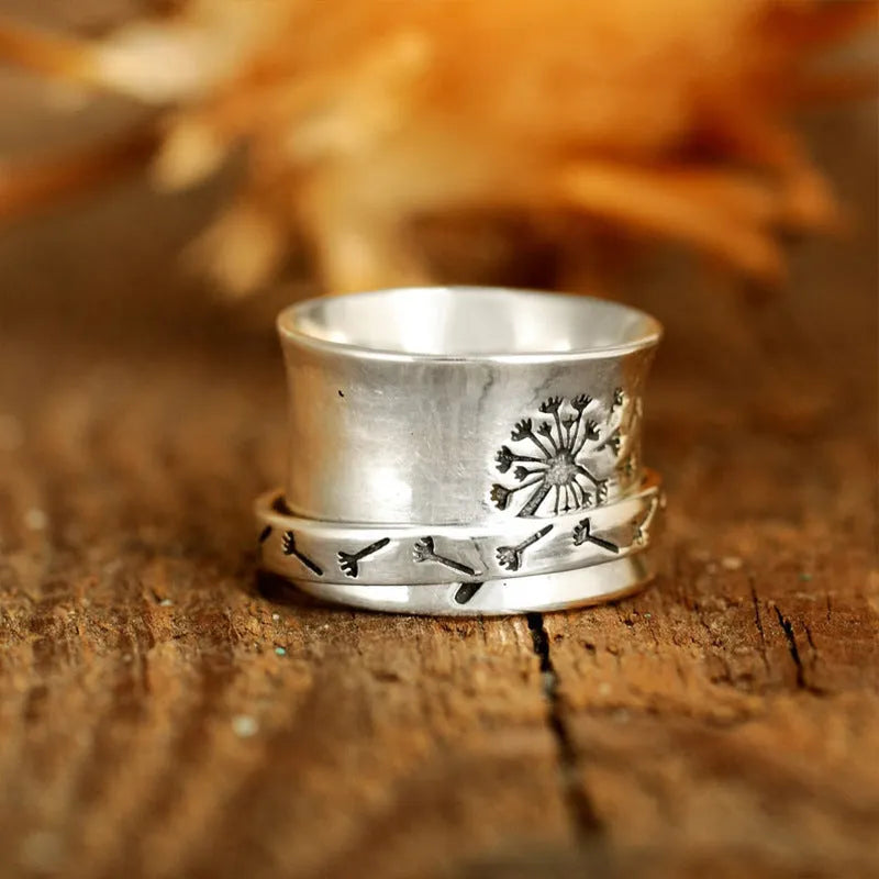 Rotatable silver-colour flower ring showing adjustable design on finger