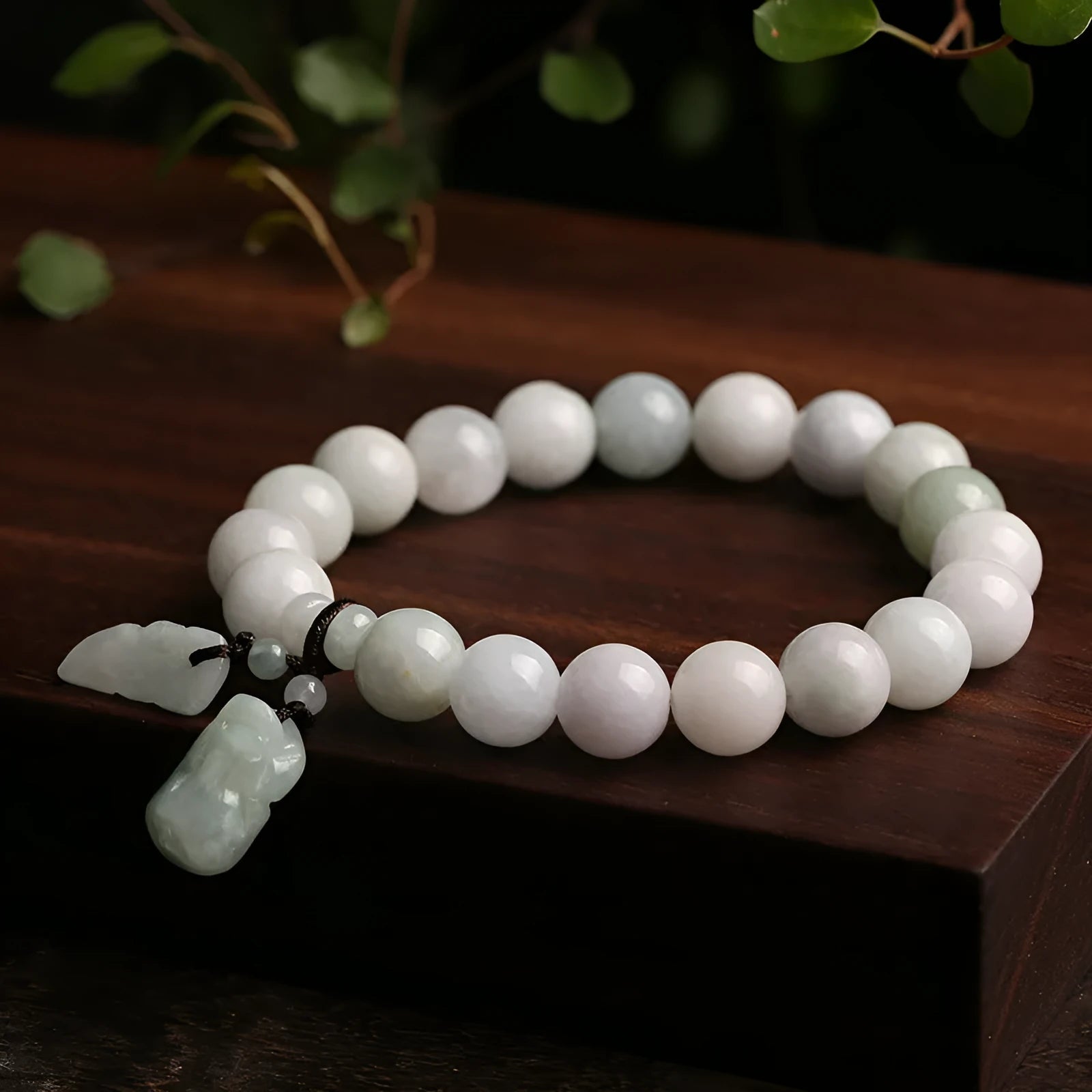 Apple green jade bracelet with carved Maitreya Buddha, gourd, and money bag beads.