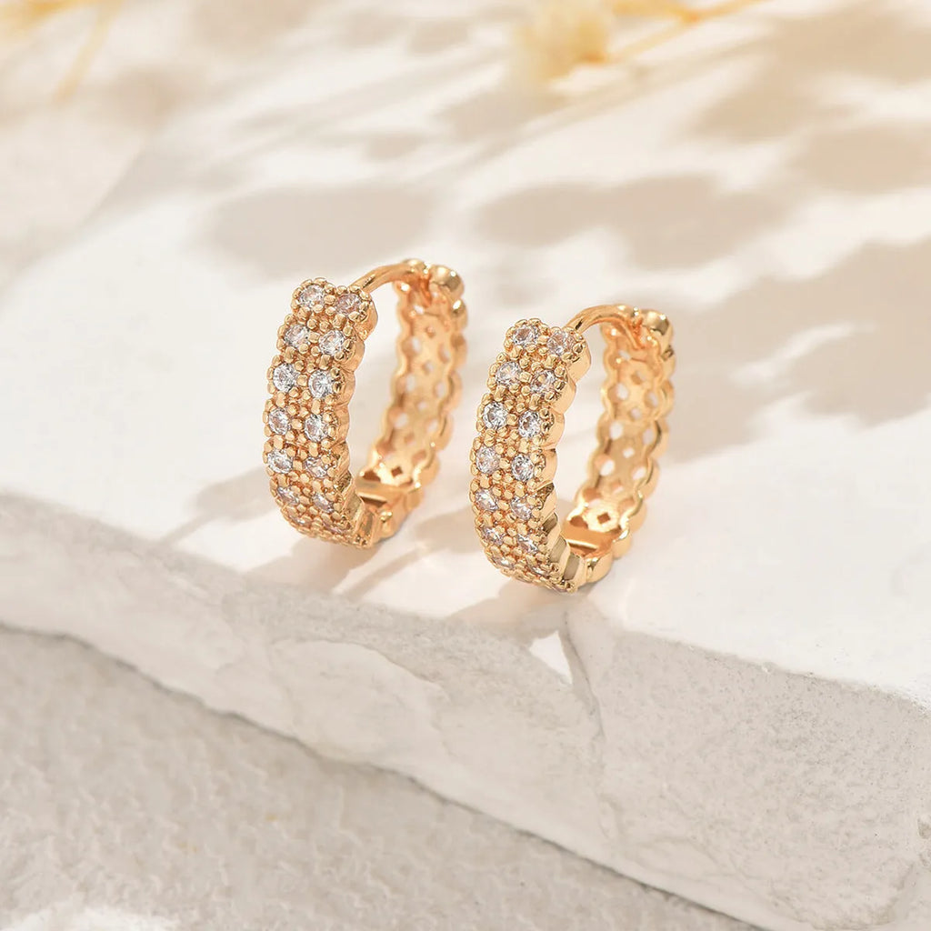 A pair of women's geometric pattern copper ear studs with round, dot, and ring details.