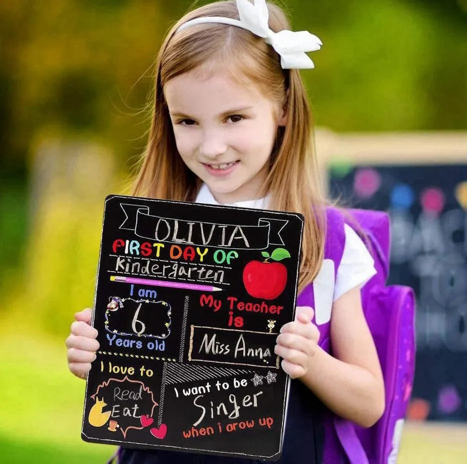 White modern wooden first day of school blackboard sign on a table.