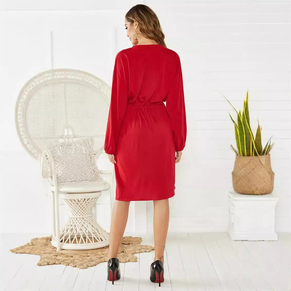 Black mid-length A-line dress with long sleeves, elastic waist, and a cinching belt laid flat.