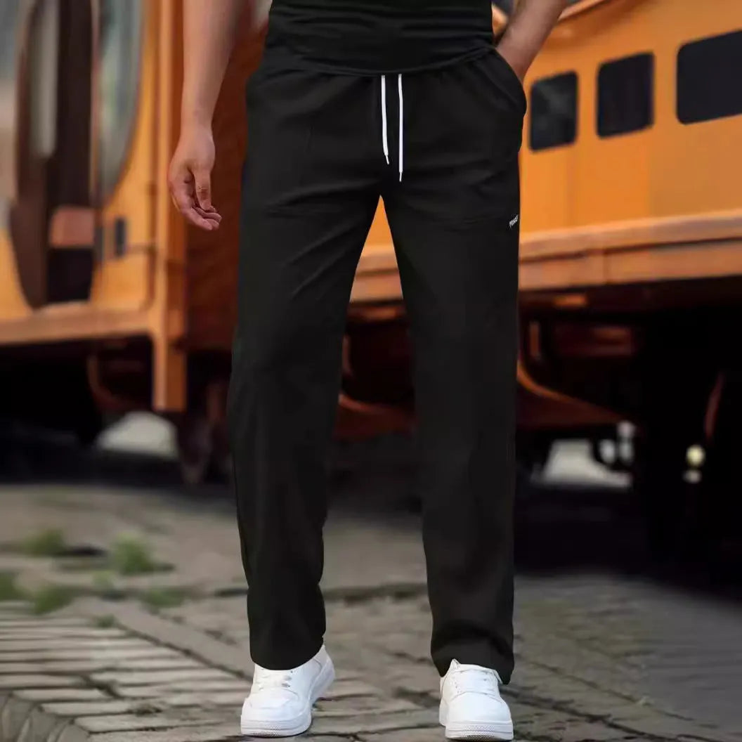 Men's polyester trousers for spring and autumn in light grey, shown in a casual setting.