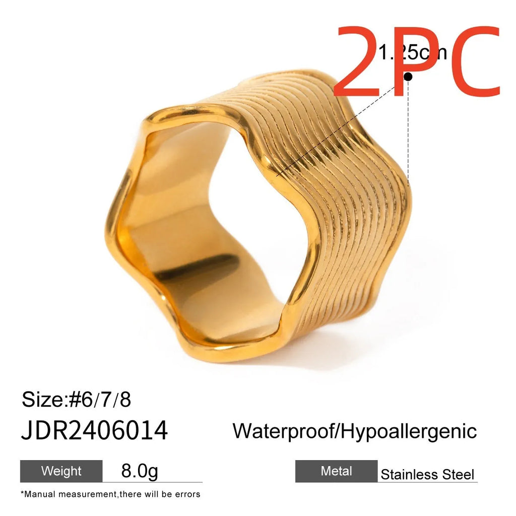 Stainless steel wide band ring with a geometric wave pattern in a metallic finish.