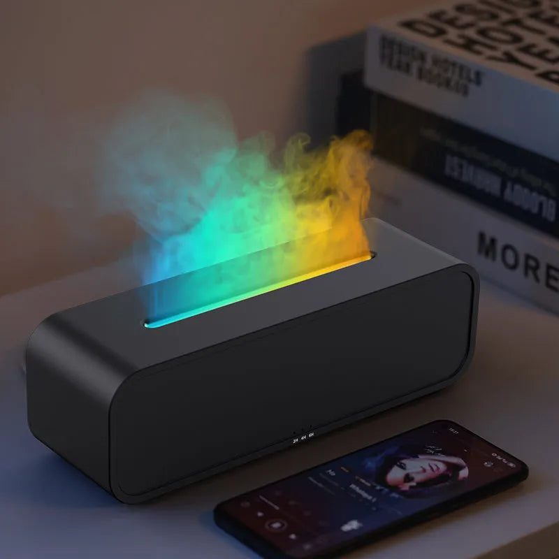 Black and white aroma diffuser with remote control on a table, showing colour-changing LED lights.
