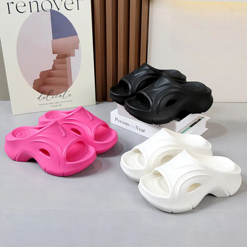 White women's EVA slippers with thick sole and round toe on a beach background.