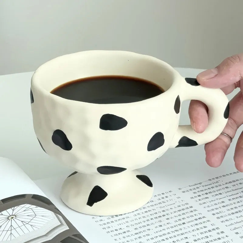 Hand-pinched irregular ceramic mug in a solid colour, showing its unique shape and modern design.