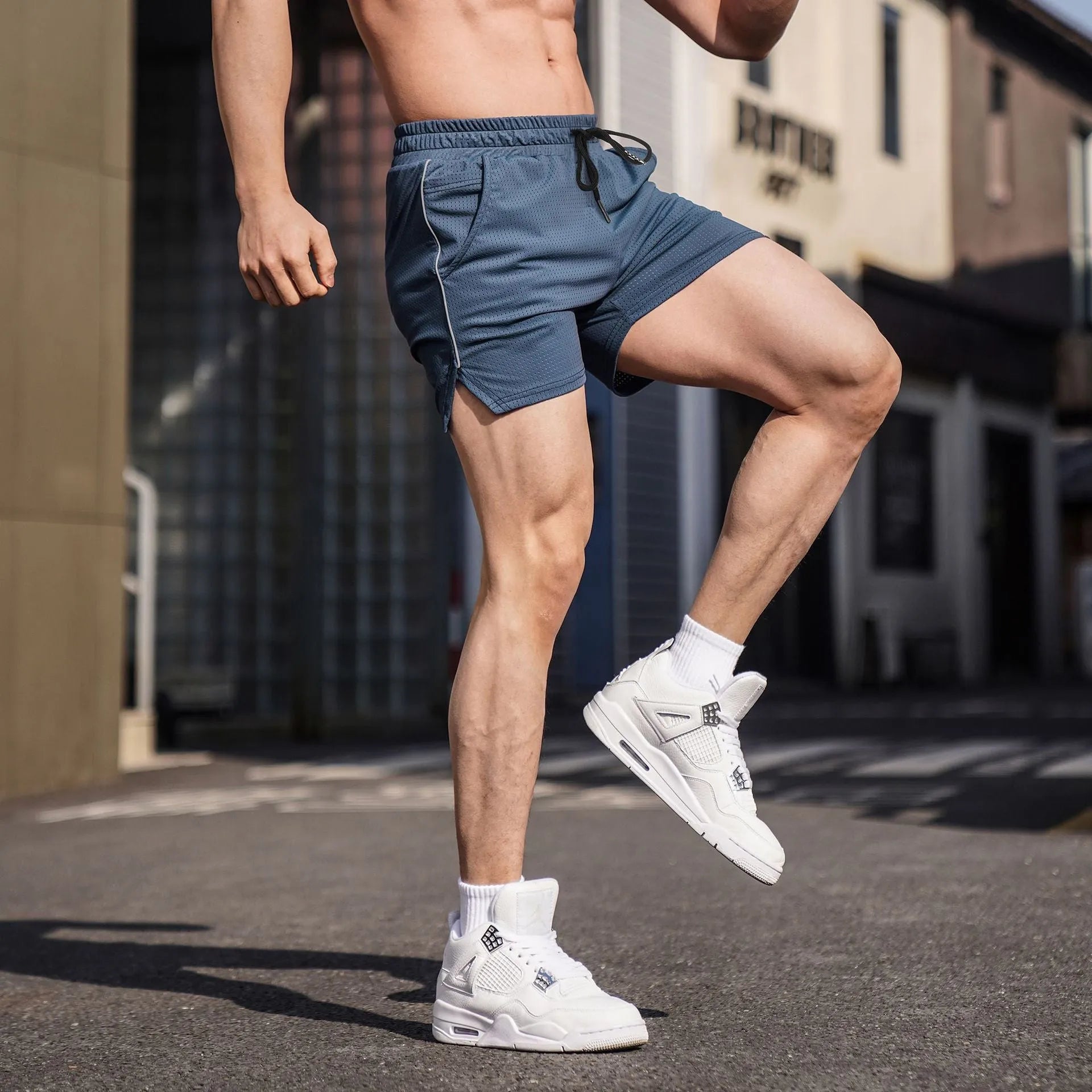 Men's black polyester fitness shorts with straight leg design on man doing exercise