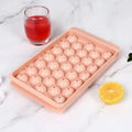 Blue silicone ice cube tray with lid showing 33 round moulds for homemade ice