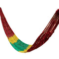 Outdoor nylon rope mesh hammock hung between two trees showing its open weave and supplied tying hardware.