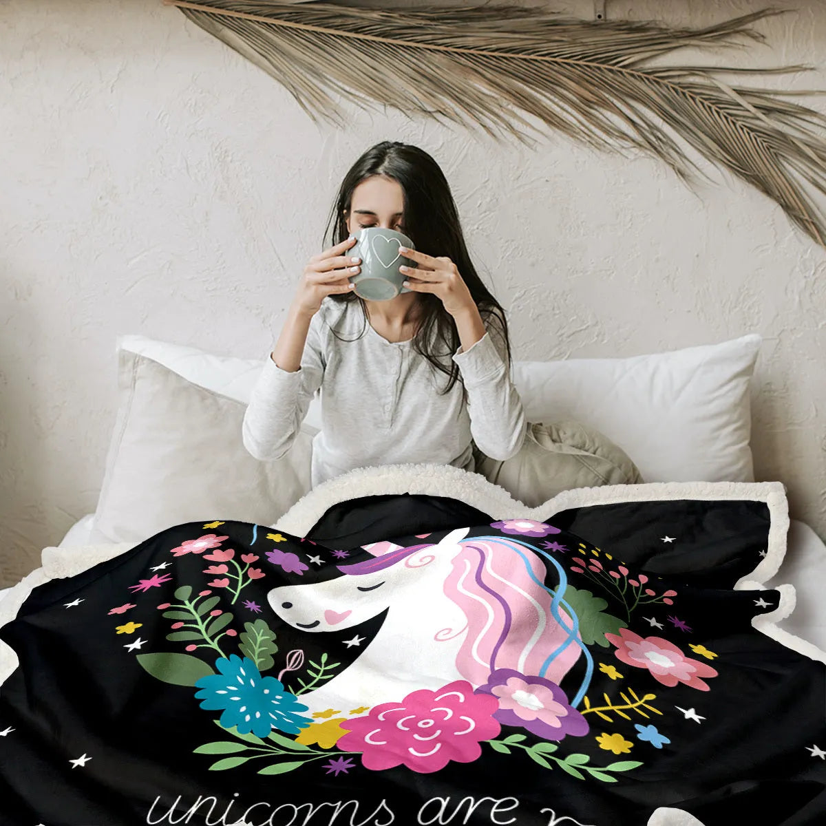 Black Sherpa fleece blanket with high weight, soft texture, and hemmed edges on a sofa