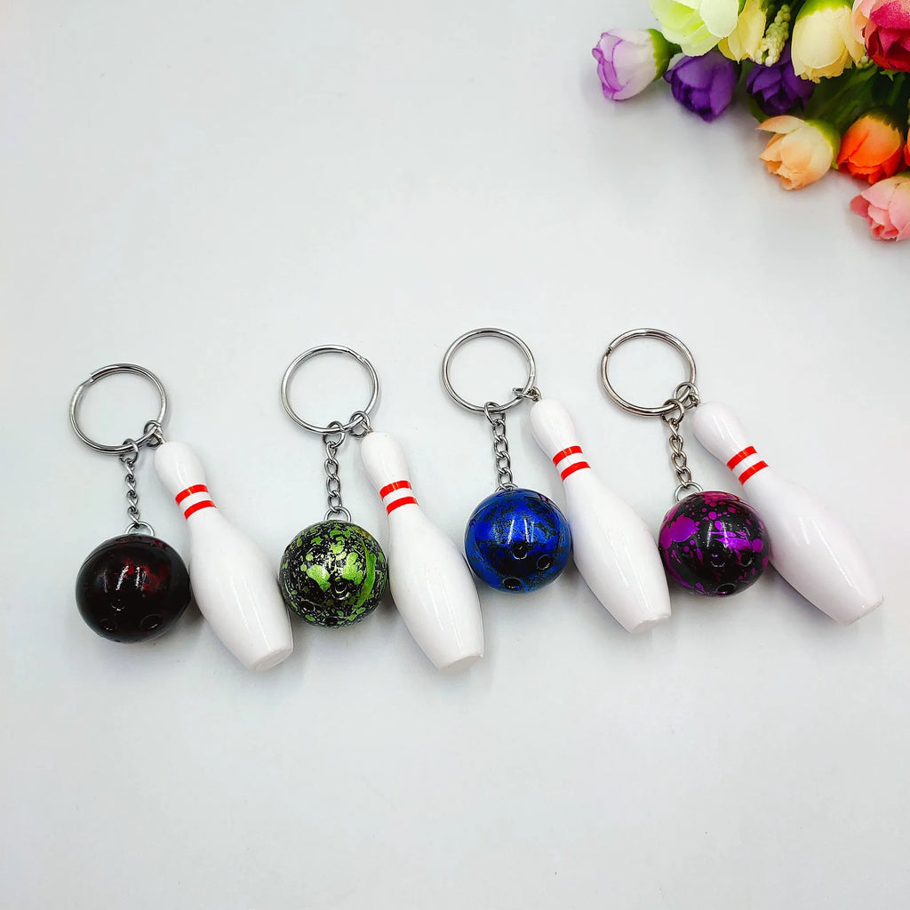 Miniature bowling ball keychain in four colour options: dark red, blue, purple, green