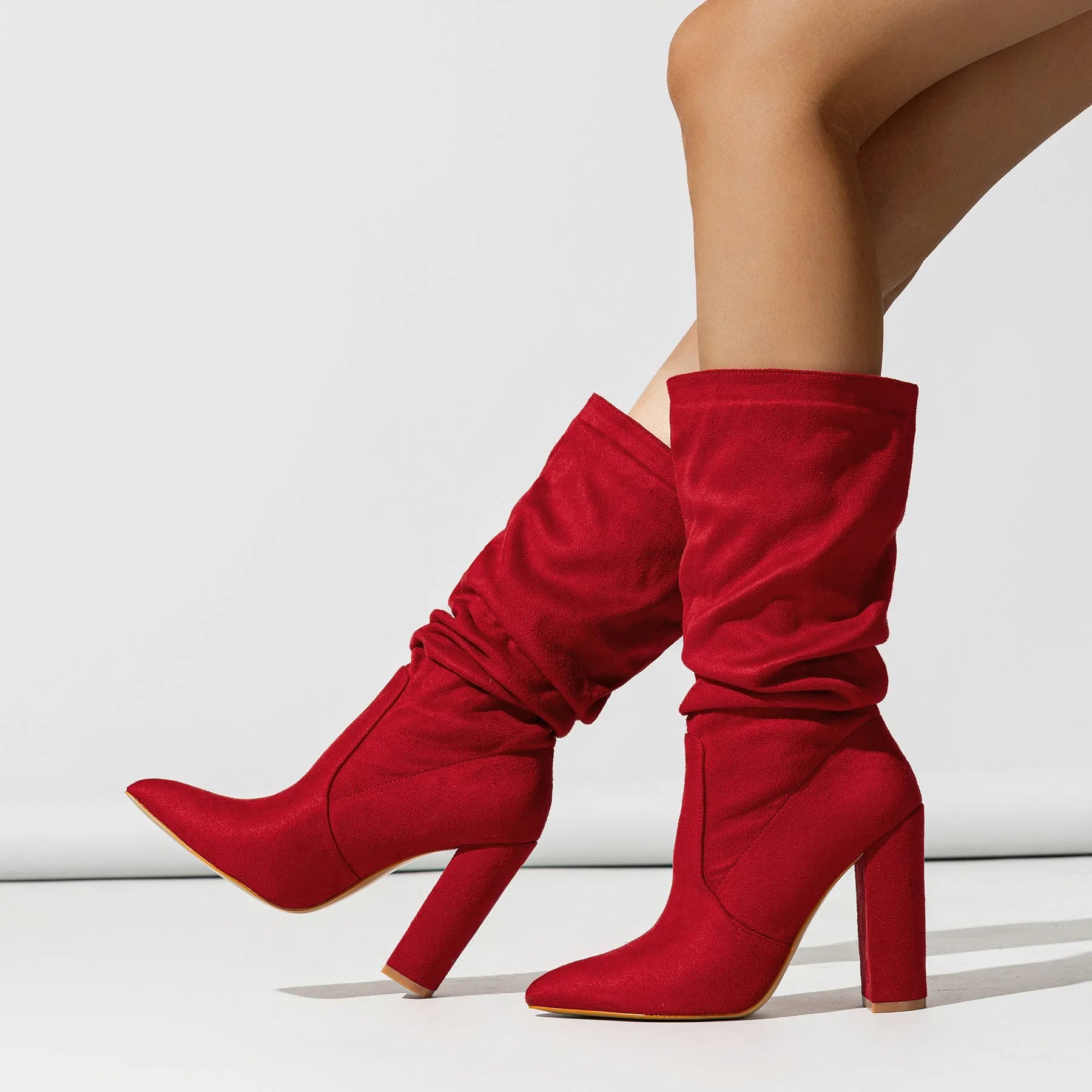 Women's black suede pointed-toe high heel boots with a chunky mid-calf design.