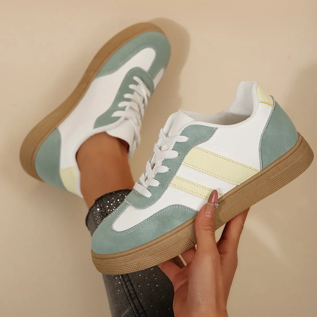 Green women's low-top retro sneakers with white cross straps and stitching on a PU upper.