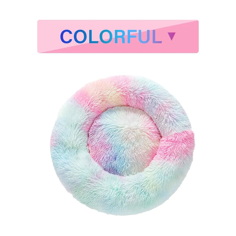 Fluffy donut-shaped dog bed in long plush material, shown in a grey colour, with a raised rim.