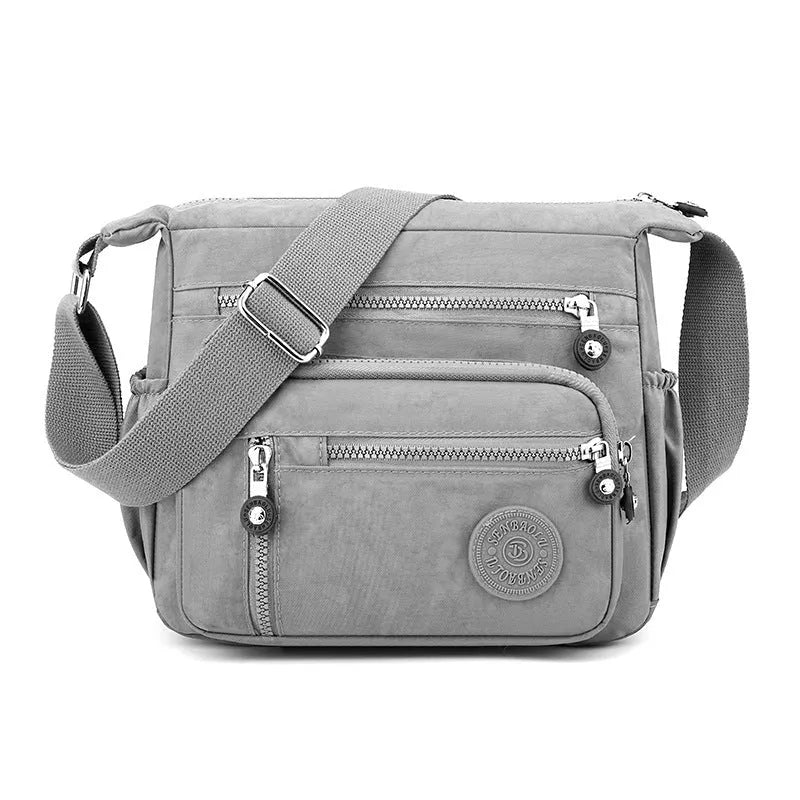 Lightweight nylon shoulder messenger bag in square vertical shape with single strap.