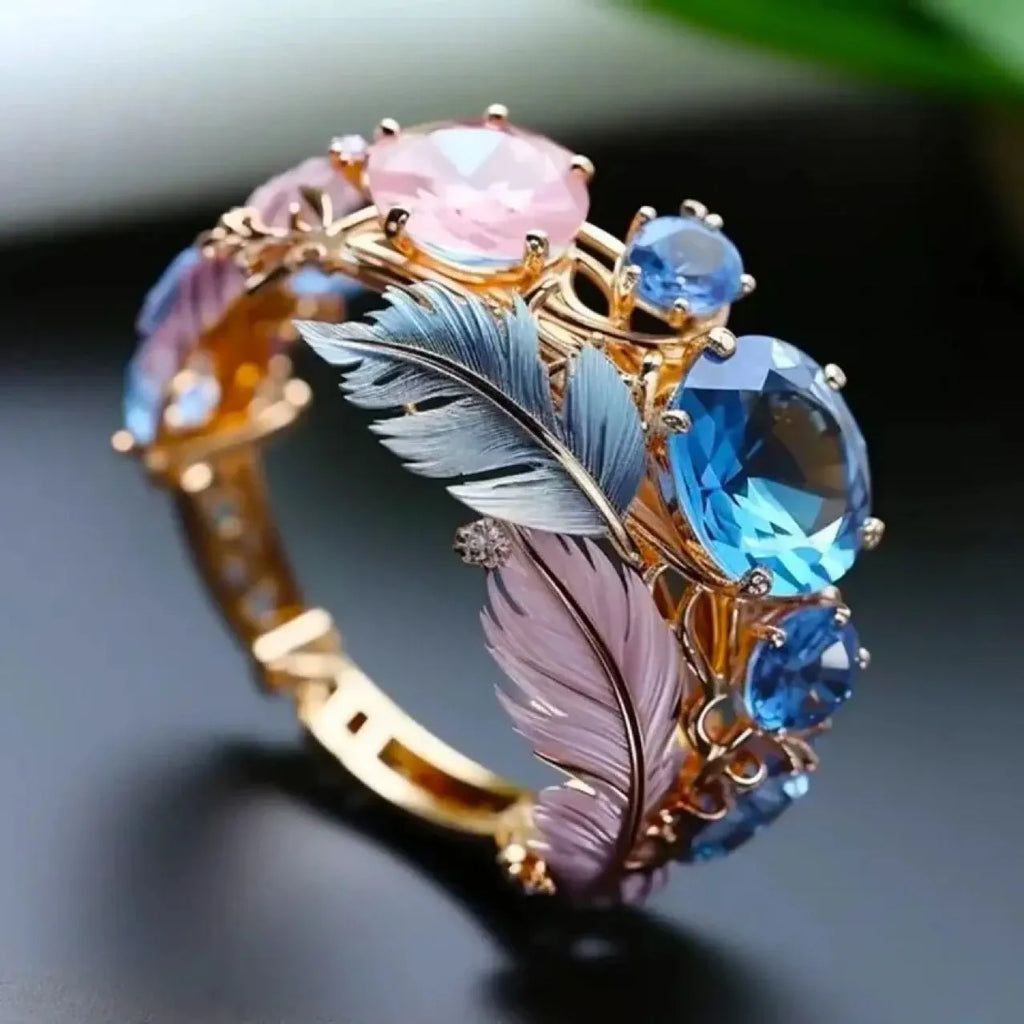Gold-colour geometric brass ring with an embossed colourful feather design and zircon inlay.