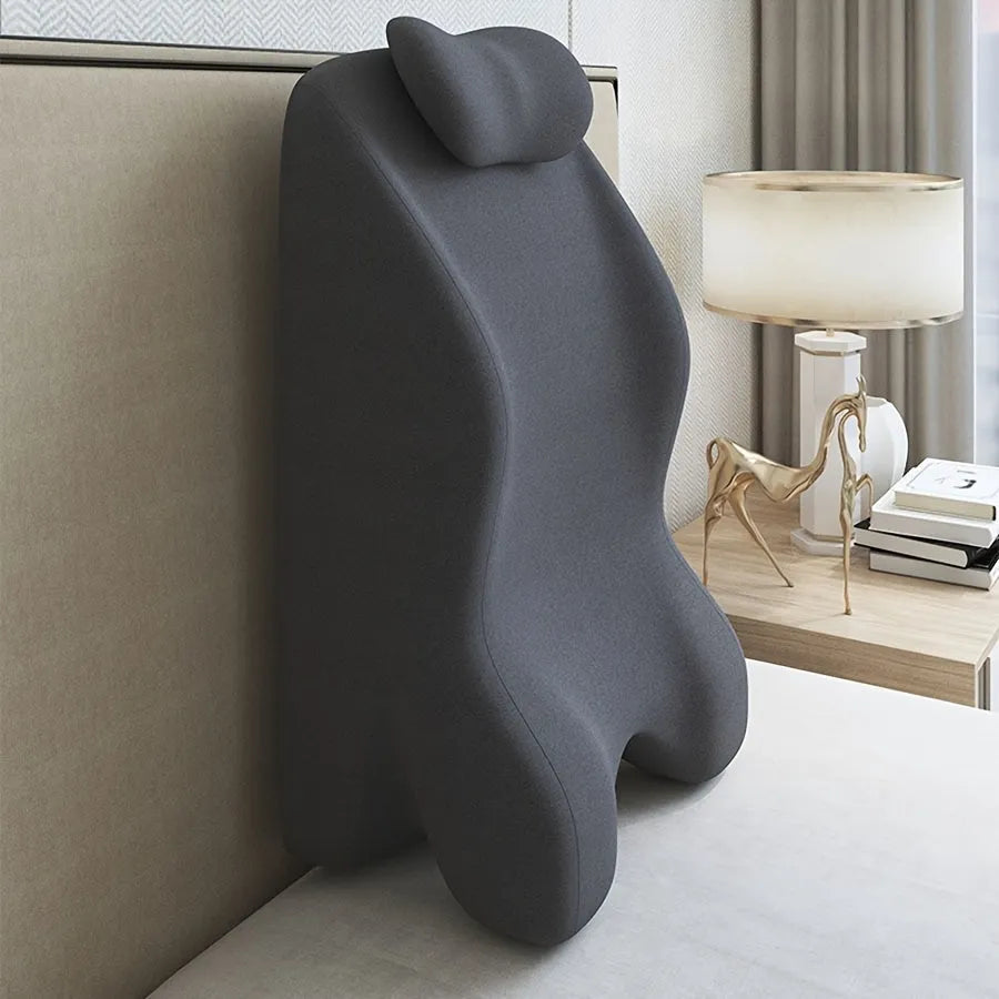 A stomach sleeper's pillow in a choice of blue, dark grey, green, or light grey, shown supporting a person lying on their front.