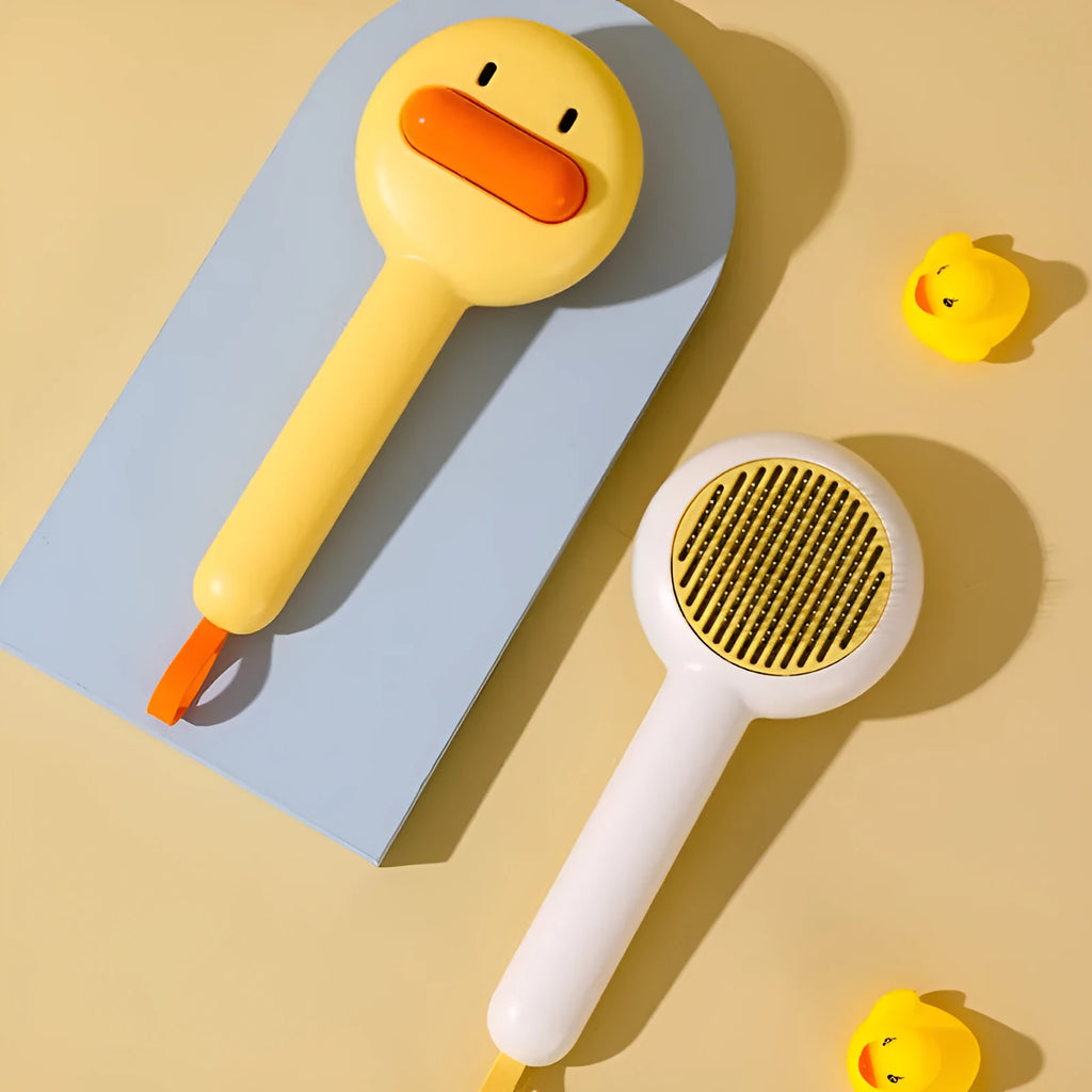 Small yellow duck-shaped pet comb with needle bristles for cat and dog grooming
