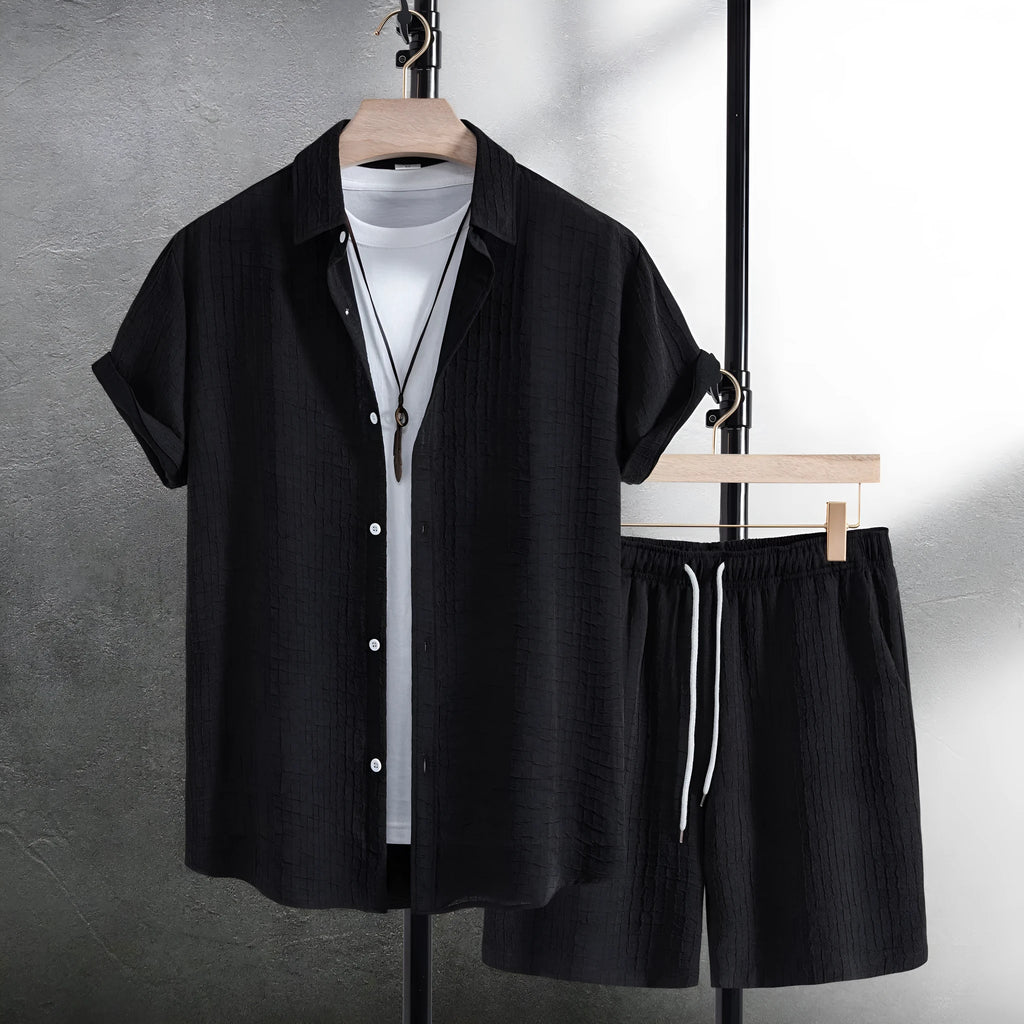 Men's black jacquard patterned short sleeve shirt and matching casual shorts laid flat.