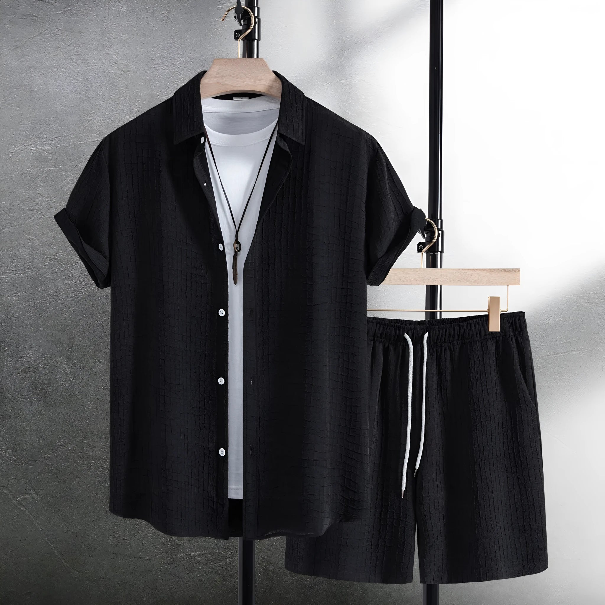 Men's black jacquard patterned short sleeve shirt and matching casual shorts laid flat.
