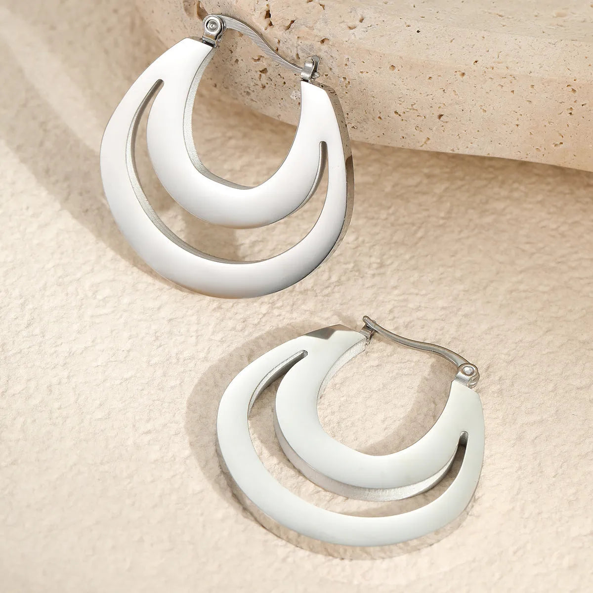 Geometric minimalist French earrings in gold and steel colours with round ring design elements