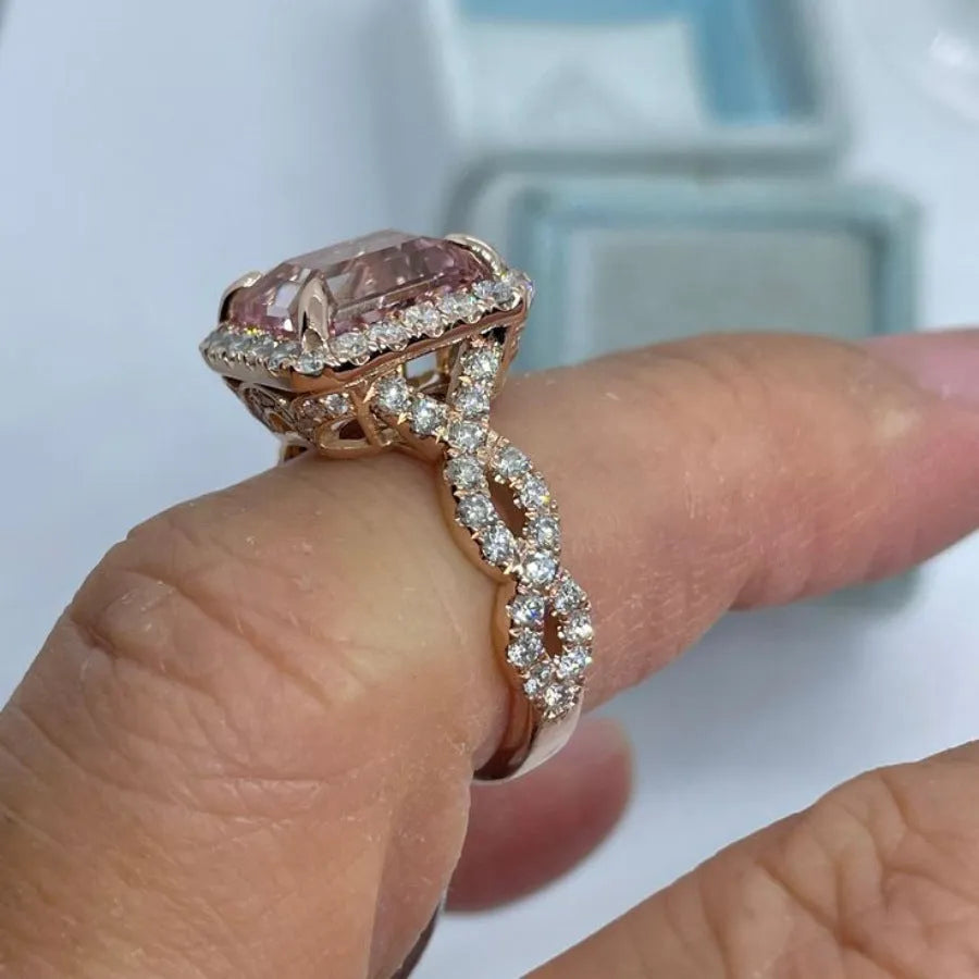 Geometric rose gold coloured alloy ring for women and men on a grey background.