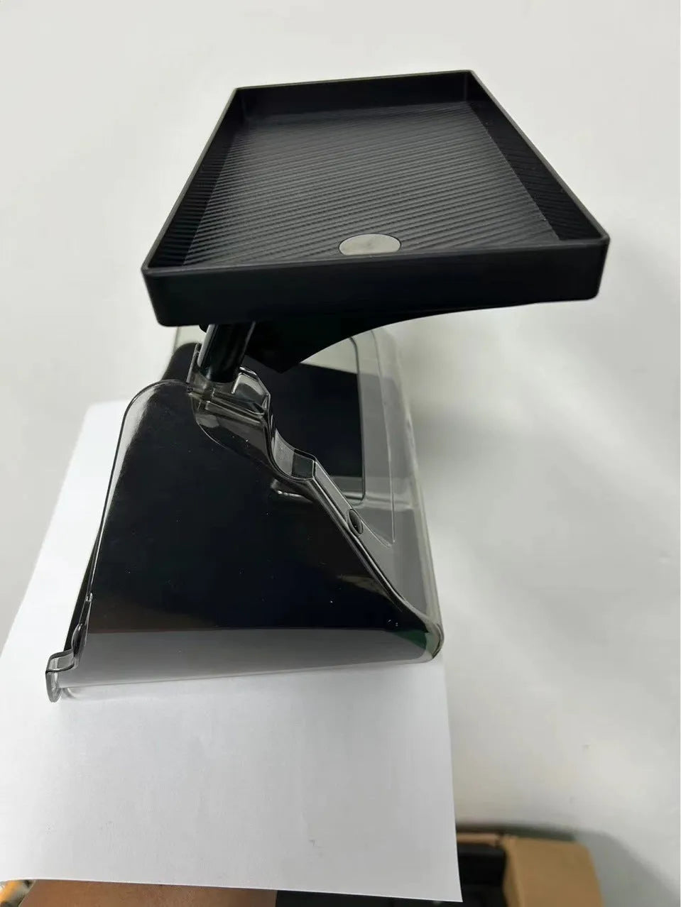 Black ABS plastic storage box installed under the screen of a Tesla Model Y centre console.