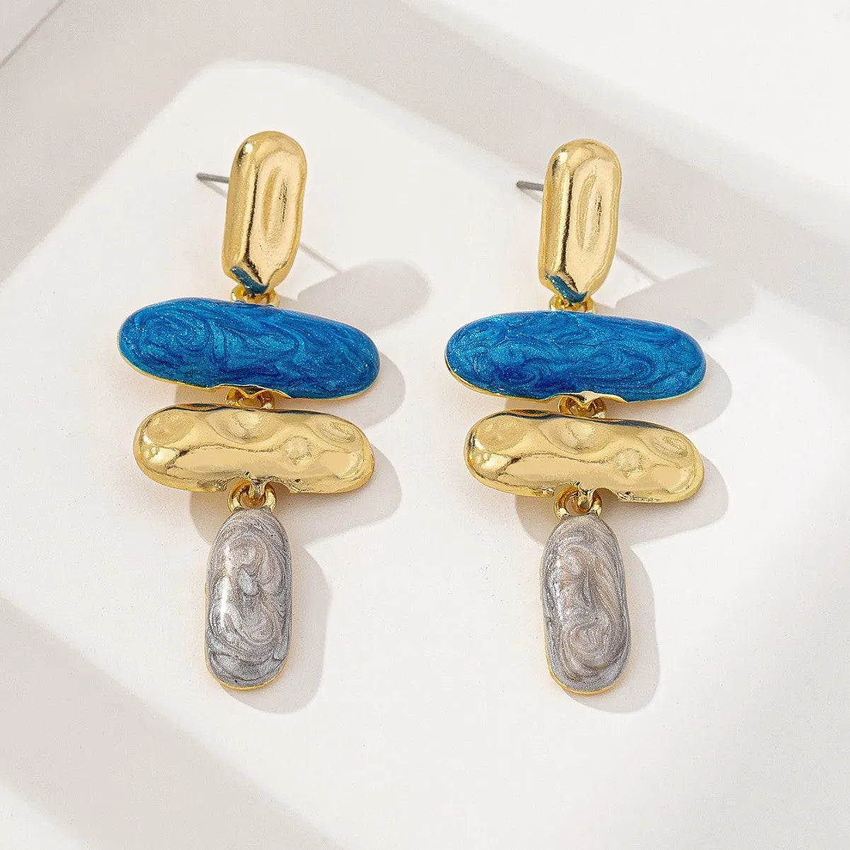 Gold-electroplated zinc alloy geometric stud earrings on a plain background.