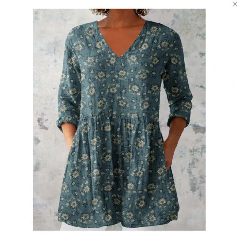 Printed women's loose dress with wide waist and three-quarter length sleeves on a hanger.