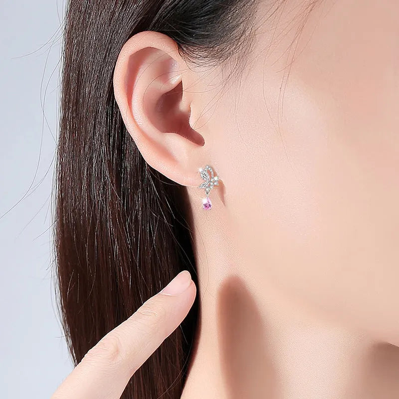 Sterling silver butterfly stud earrings with crystal details on woman's earlobe