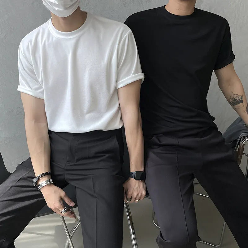 Man wearing a slim fit black cotton t-shirt with a round neck and regular sleeves.