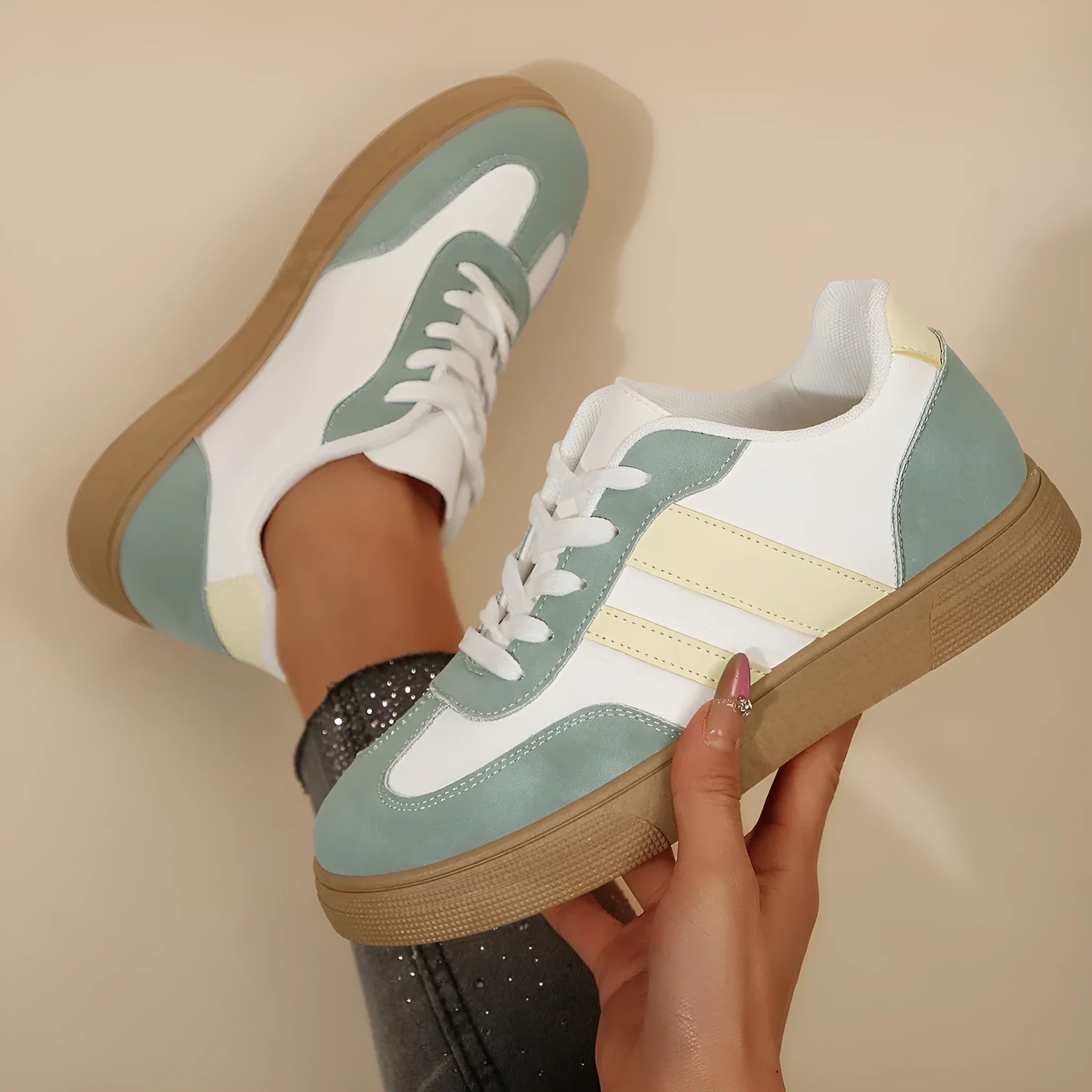 Green women's low-top retro sneakers with white cross straps and stitching on a PU upper.