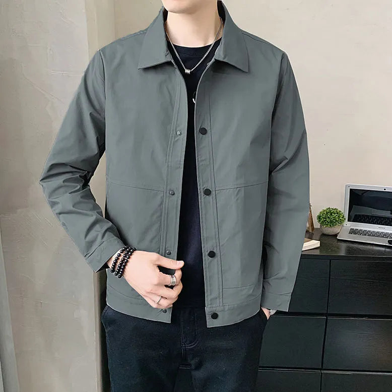 Man wearing a Korean style lightweight single-layer jacket in grey, showing front zip and long sleeves.