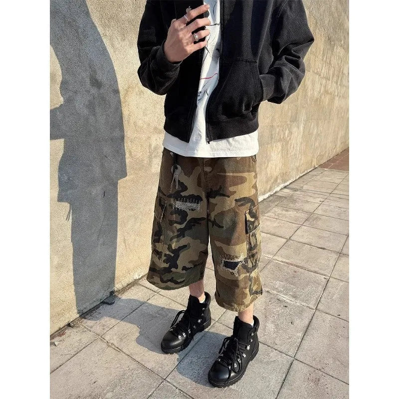 Men's loose fit camouflage patch ripped cropped jeans in a straight leg style.