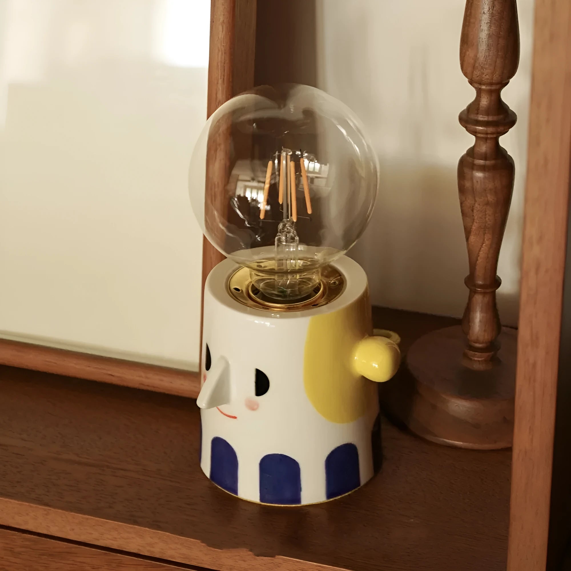 Handmade ceramic lamp with ball headlight design on bedside table