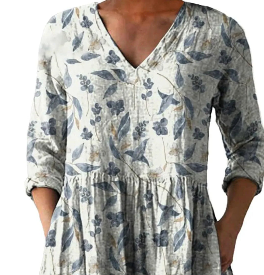 Printed women's loose dress with wide waist and three-quarter length sleeves on a hanger.
