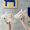Women's pink casual sneakers with thick sole and cross-shoulder straps on a white background